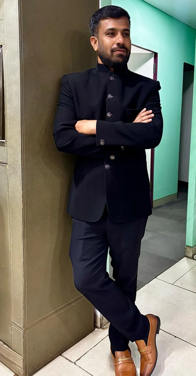 Customer in a full black jodhpuri bandhgala suit with tan loafers at Bespoke Studio