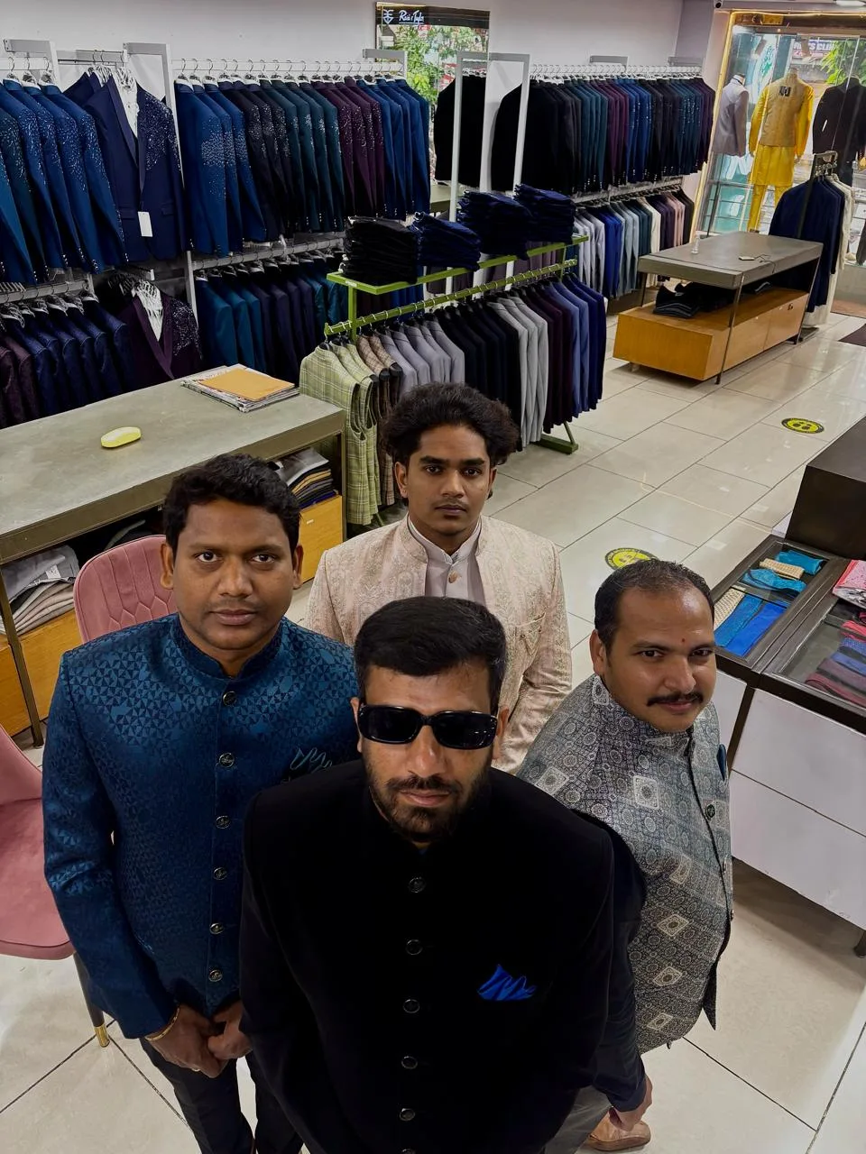 Four customers together in bandhgalas and a cream sherwani on the Bespoke Studio showroom floor