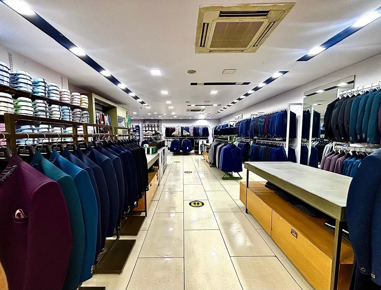 The ready-to-wear floor at Bespoke Studio — racks of blazers and suits in jewel tones, folded shirts and a suited mannequin